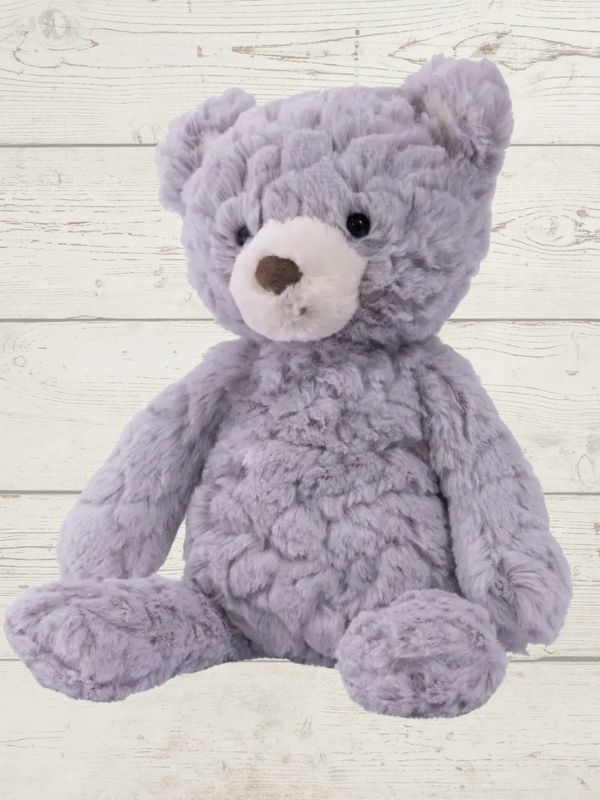 a grey bear sitting on a wooden surface