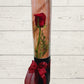 a red rose inside a black cylinder with ribbon