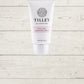 A tube of Tilley hand and nail cream against a white wooden background.