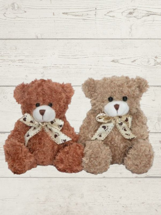 Two brown teddy bear plush toys with bow ties, one larger than the other, placed on a wooden surface.