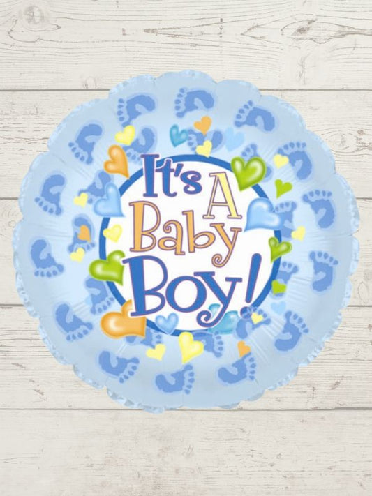 round blue balloon with baby feet and hearts, in centre ït's a boy" on a wooden background