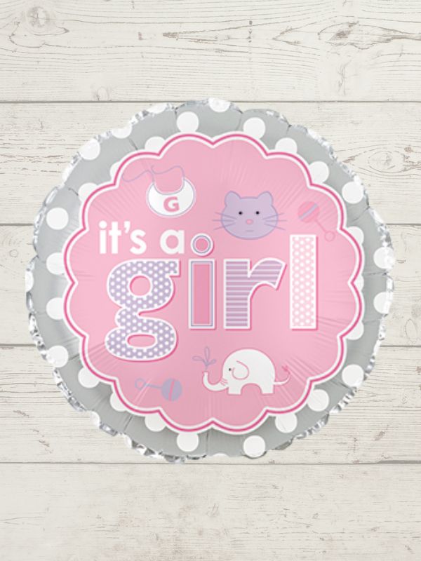 round pink and grey balloon with it's a girl written on it against a white wooden background. 