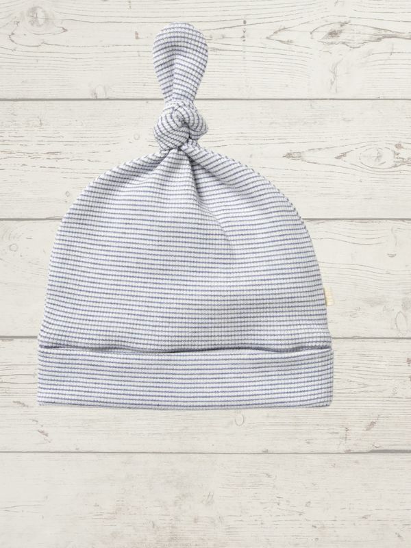 Striped baby hat on a light wooden surface
