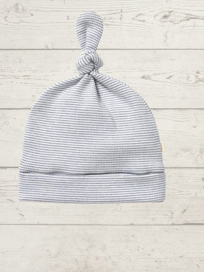 Striped baby hat on a light wooden surface