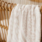 White textured fabric draped over a wooden chair