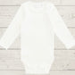 White long sleeve bodysuit on a light wooden surface