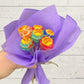 A bouquet of Chupa Chups lollipops wrapped in purple paper.