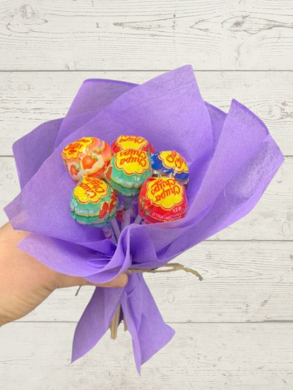A bouquet of Chupa Chups lollipops wrapped in purple paper.