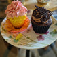 2 cupcakes on a floral plate with blurred background