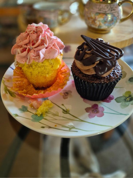 2 cupcakes on a floral plate with blurred background