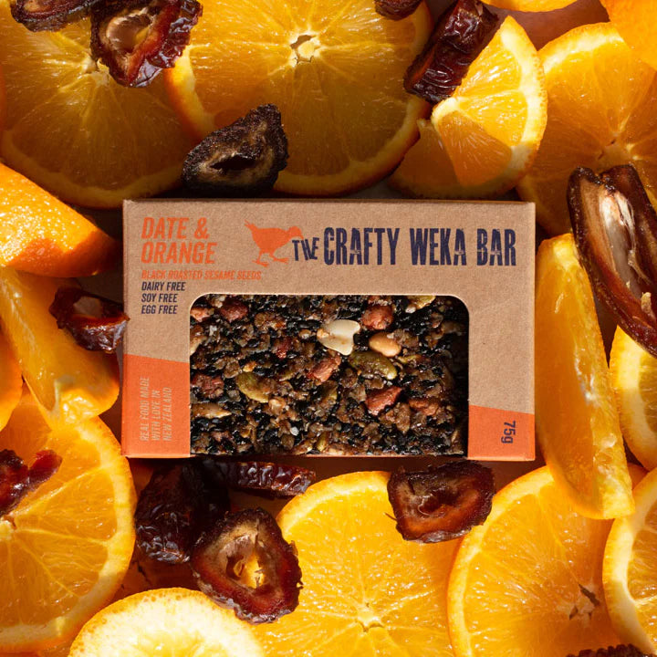 The Crafty Weka Bar packaging surrounded by sliced oranges and dates