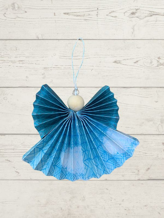 blue coloured hanging angel with a wooden bead on a wooden surface