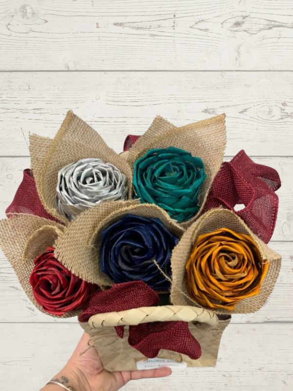 colorful flax flowers wrapped in a kete with a wooden background