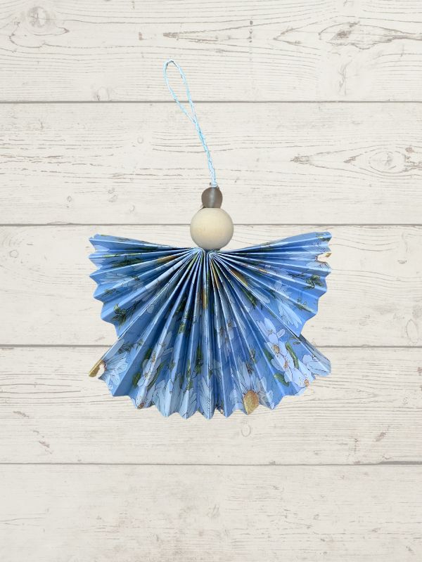 floral decoration, angel shaped with a wooden bead on a wooden surface