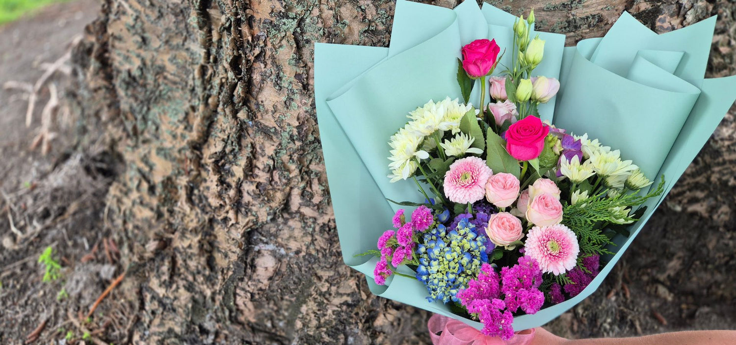A bouquet of flowers sitting in front of a tree