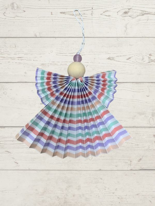 Decorative angel with striped wings on a wooden surface