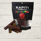 chocolate licorice logs with a packet with Kapiti Candy co on it on a wooden surface