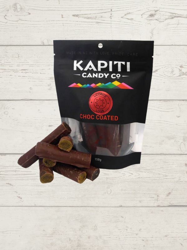 chocolate licorice logs with a packet with Kapiti Candy co on it on a wooden surface