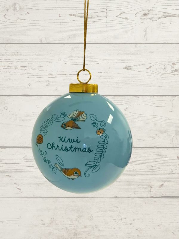 blue bauble with nz birds and kiwi christmas written on it on a wooden background