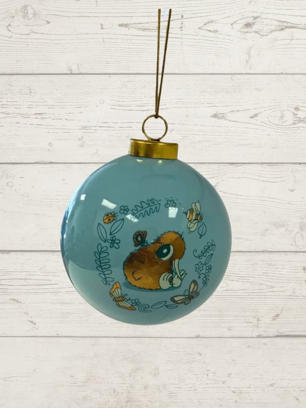 kuwi the kiwi on a blue bauble on a wooden background