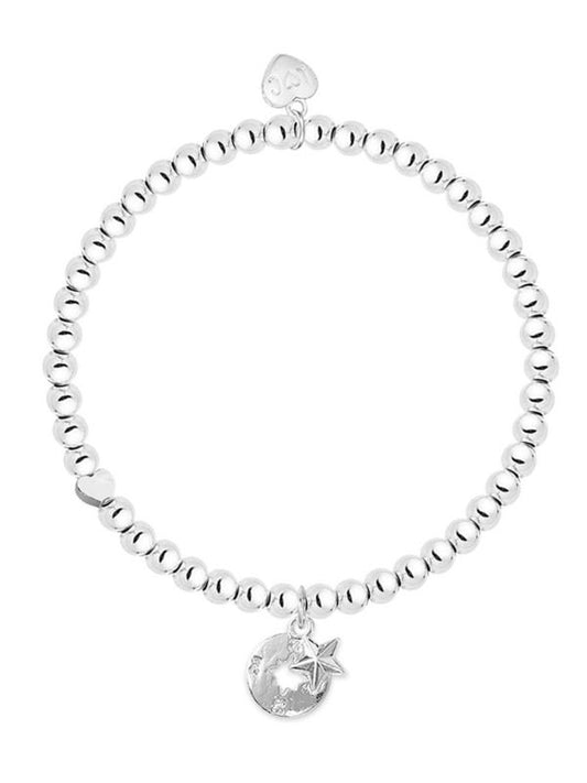 Silver beaded bracelet with moon and star charm on a white background