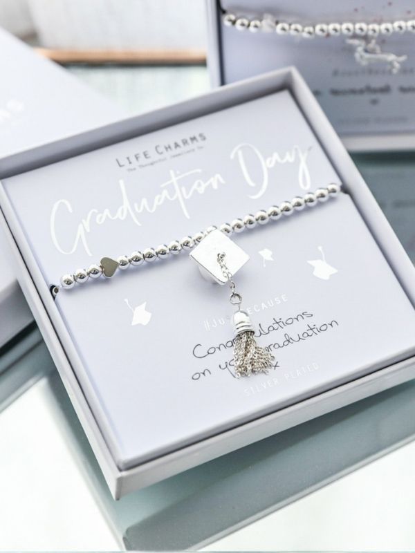 Graduation-themed bracelet with charm in a gift box on a light background