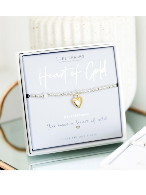 Gold heart bracelet in a 'Life Charms' packaging on a white surface
