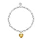 Pearl bracelet with a gold heart charm on a white background