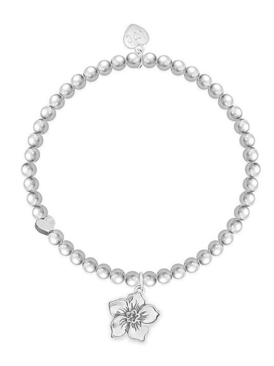 Pearl bracelet with a silver flower charm on a white background