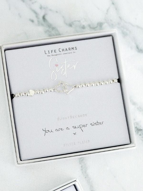 Silver bracelet with 'Sister' charm on a Life Charms branded card with marble background