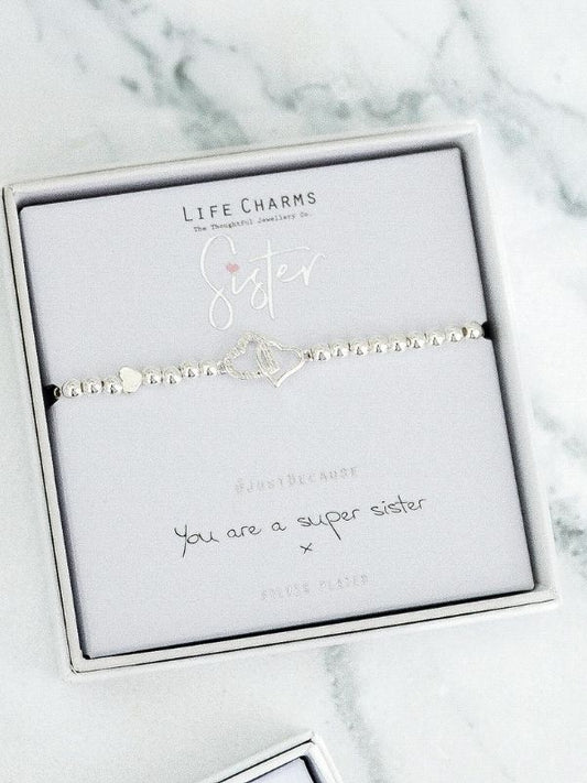 Silver bracelet with 'Sister' charm on a Life Charms branded card with marble background