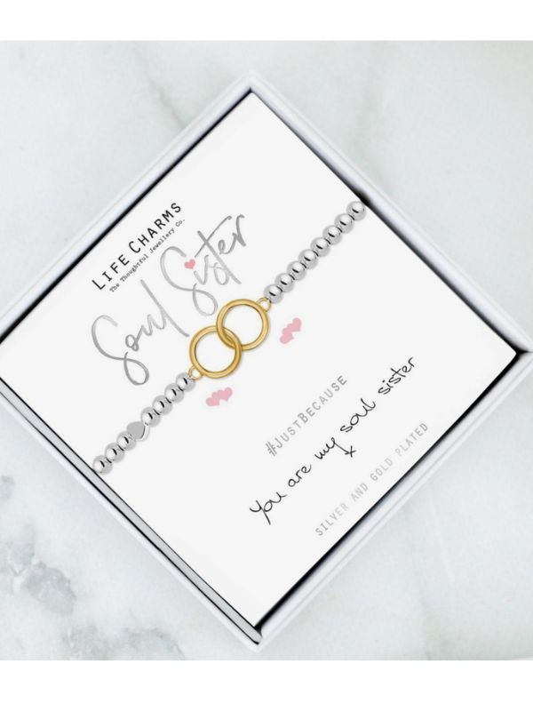 Bracelet with 'Soul Sister' text on a white card with gold and silver charms.