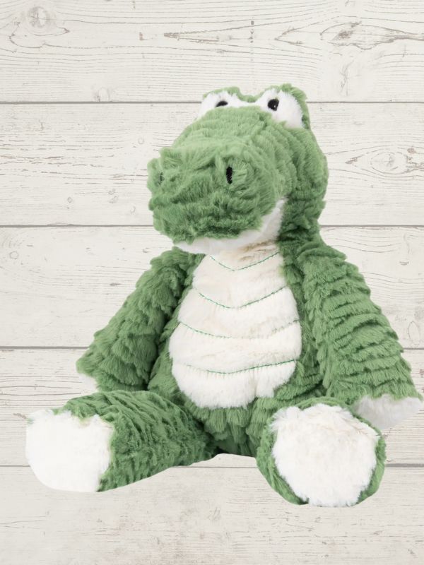 A plush toy resembling a green marshmallow with a crocodile-like face, made from soft fabric, designed for cuddling and play.