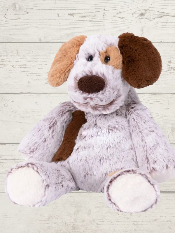A plush toy resembling a marshmallow puppy with embroidered details, soft fabric, and a stuffed design, placed against a wooden background.