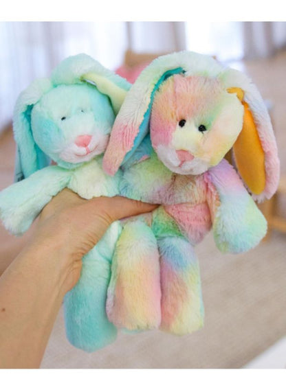 Two colorful plush toys resembling bunnies held by a hand against a neutral background.
