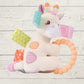 Giraffe-shaped toy with colorful patches and a teething ring on a wooden surface