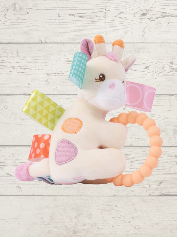 Giraffe-shaped toy with colorful patches and a teething ring on a wooden surface