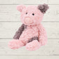 Pink and gray stuffed pig soft toy on a light wooden surface