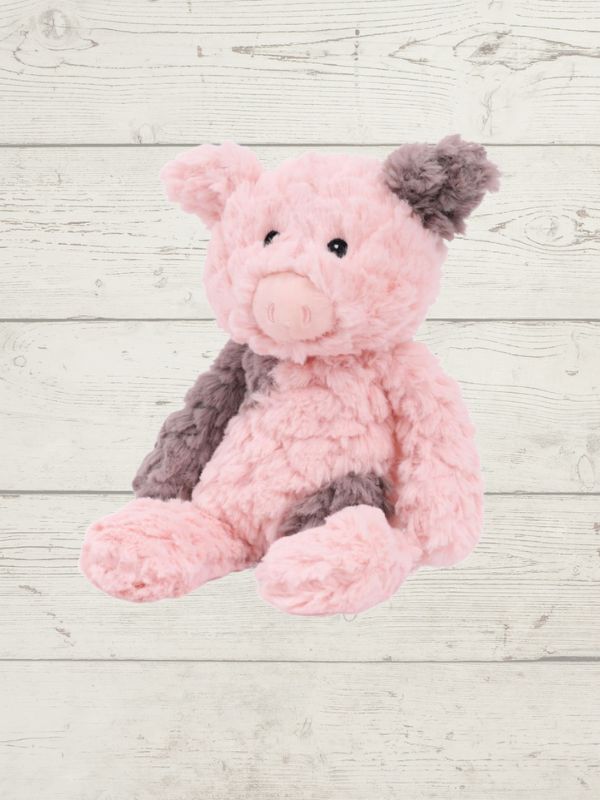 Pink and gray stuffed pig soft toy on a light wooden surface