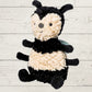 Plush bee soft toy on a light wooden background