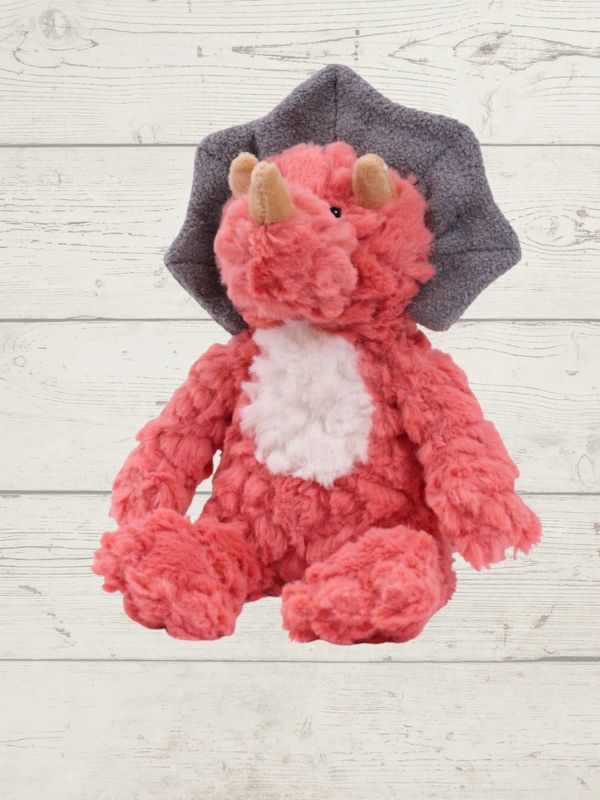 Plush toy dinosaur on a light wooden background