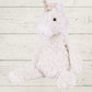 Plush unicorn soft toy on a light wooden background