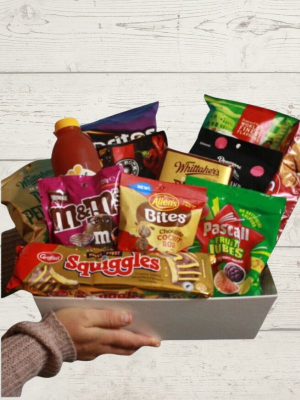 A gift box filled with various snack food items including chocolates, chips, and biscuits.