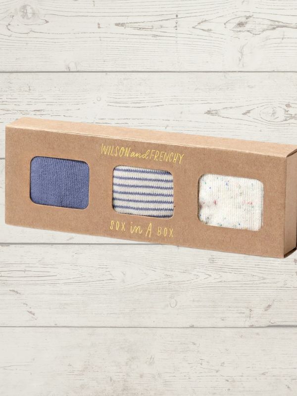 Box of socks with three pairs inside on a wooden surface