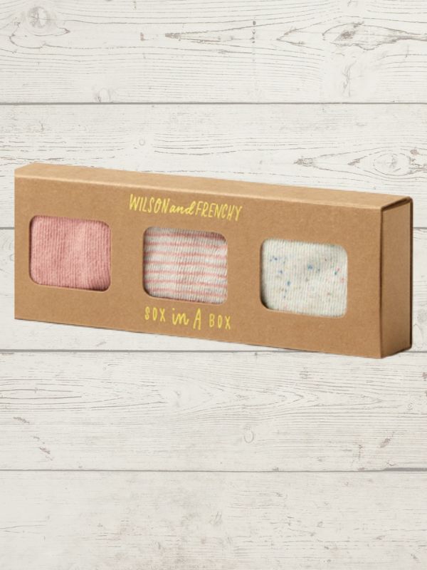 Box of socks with 'Wilson and Frenchy' branding on a wooden surface