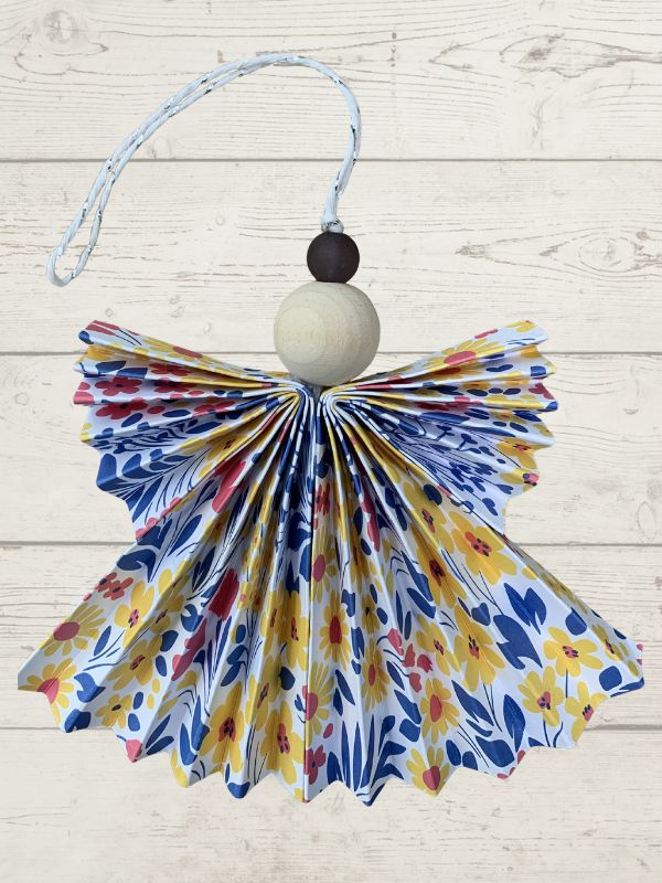 Decorative angel ornament with floral pattern on a wooden surface