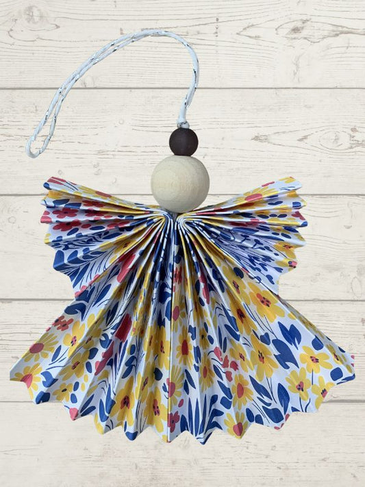 Decorative angel ornament with floral pattern on a wooden surface