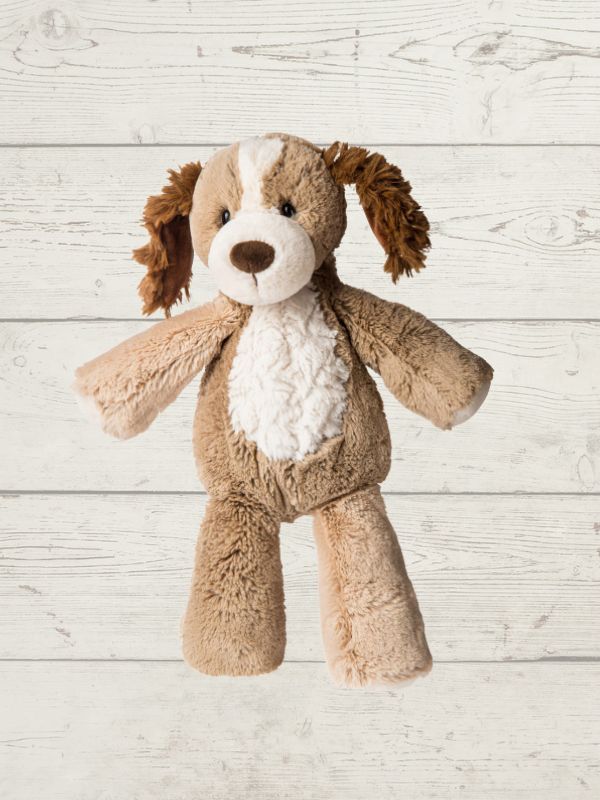 A plush stuffed dog toy with brown and cream fur, posed against a light gray wood plank background.