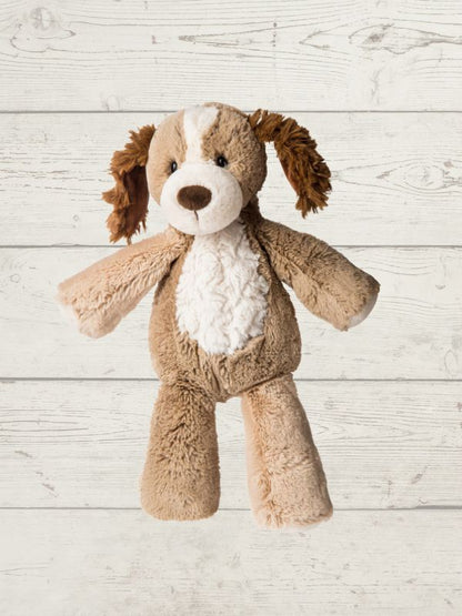A plush stuffed dog toy with brown and cream fur, posed against a light gray wood plank background.