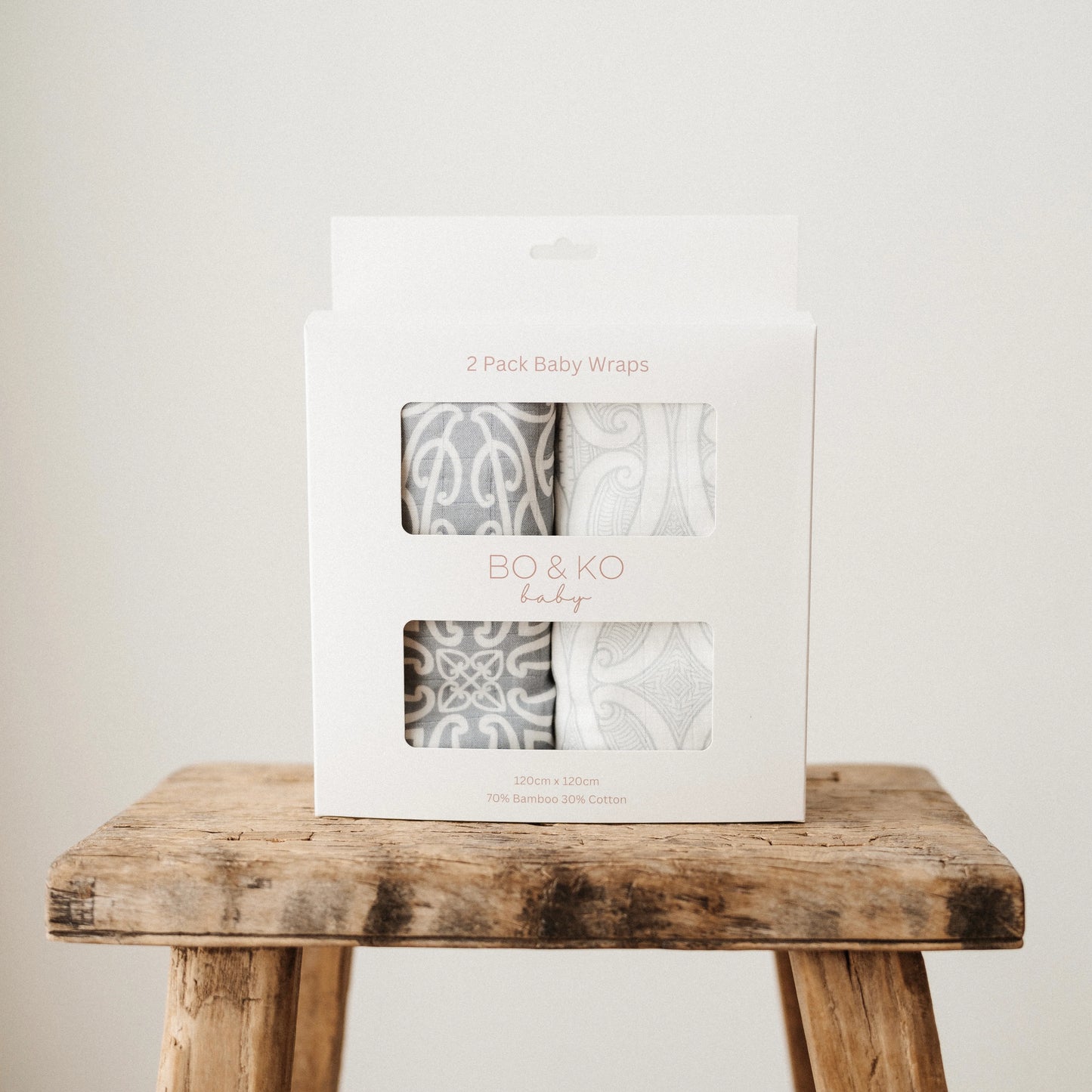 Two-pack of baby wraps in a BO & KO branded box on a wooden stool.